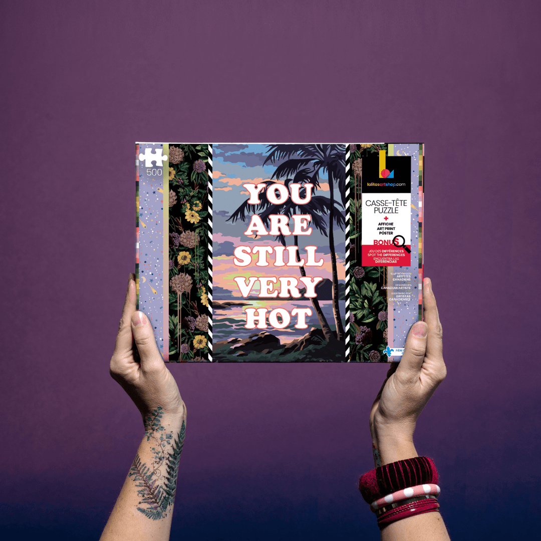Hands holding the "Puzzle 500 pieces «Still Very Hot »" box against a purple background.