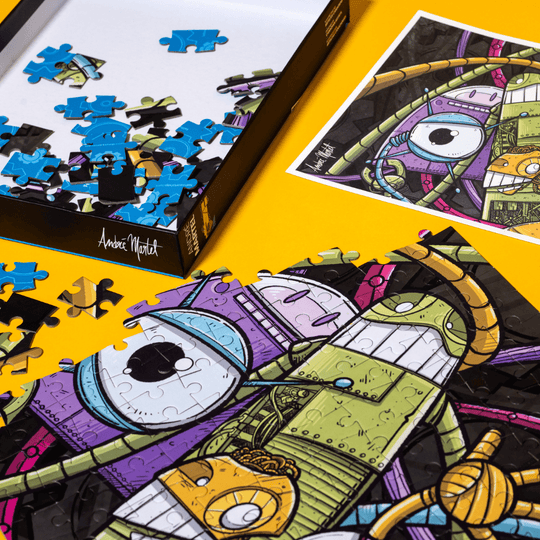 Close-up of puzzle pieces, a signed art print, and the puzzle box of &