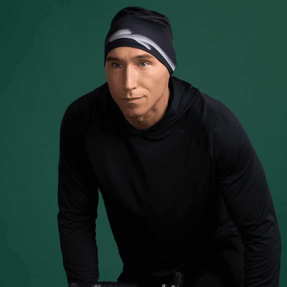 Man wearing a black beanie with a graphic stripe pattern, looking to the side.