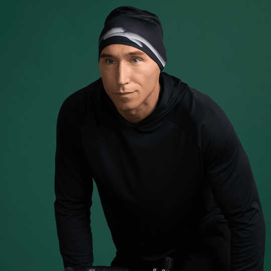 Man wearing a black beanie with a graphic stripe pattern, looking to the side.