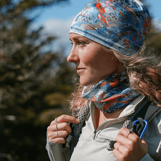 Woman in a forest, wearing the Sphénédon Beanie and a coordinating neck gaiter.