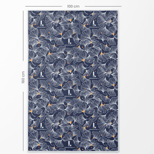 Serviette réversible en microfibre printanière dépliée avec des dimensions de 100 cm x 160 cm, montrant le verso avec un motif de feuilles de ginkgo marine.