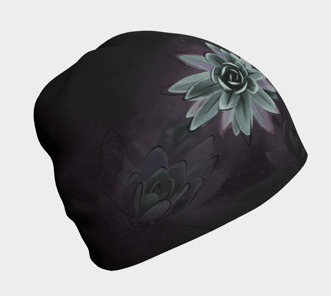 Black beanie with a close-up graphic of a pale green succulent flower against a dark, muted background.