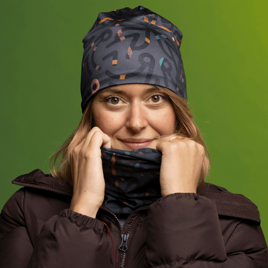 Woman wearing a brown puffer jacket and the Symetrick Gray Multifunctional Tube as a neck gaiter.