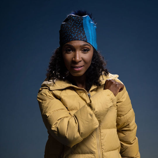Close-up of the woman wearing the Teal Flakes Beanie as a headband, with the art pattern clearly visible.