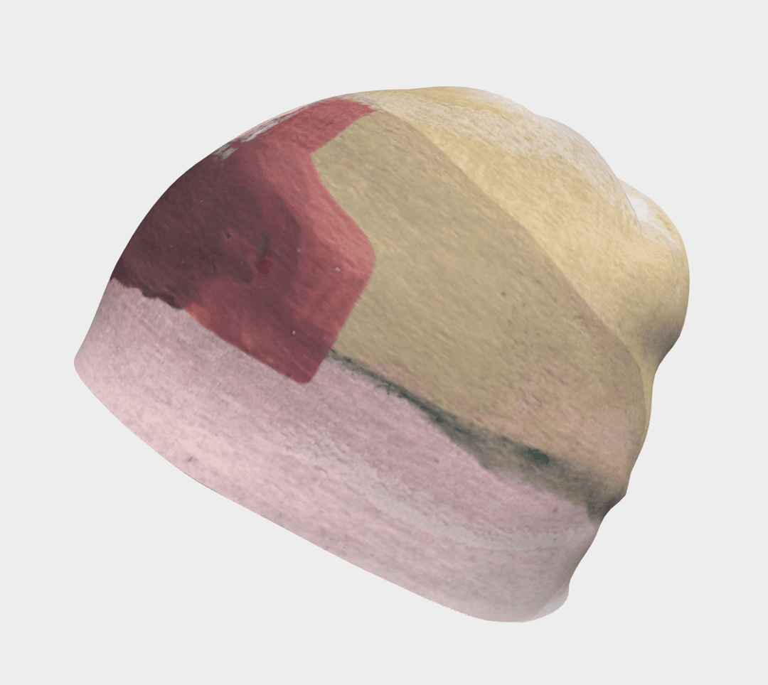 Side view of The Space Between Beanie, highlighting the abstract pattern with shades of yellow and pink.