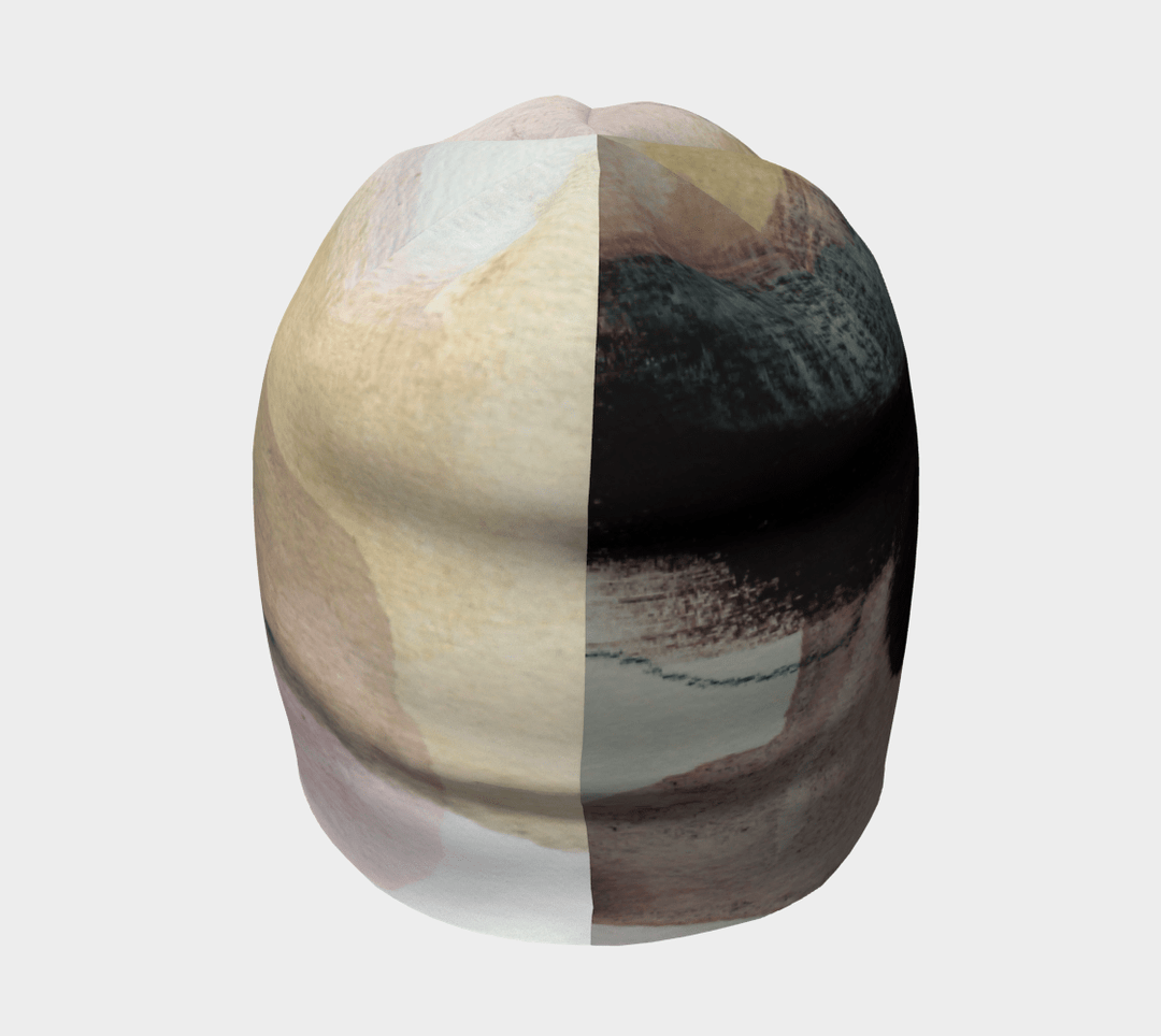 Front view of The Space Between Beanie, split in its pattern to show contrasting abstract elements.