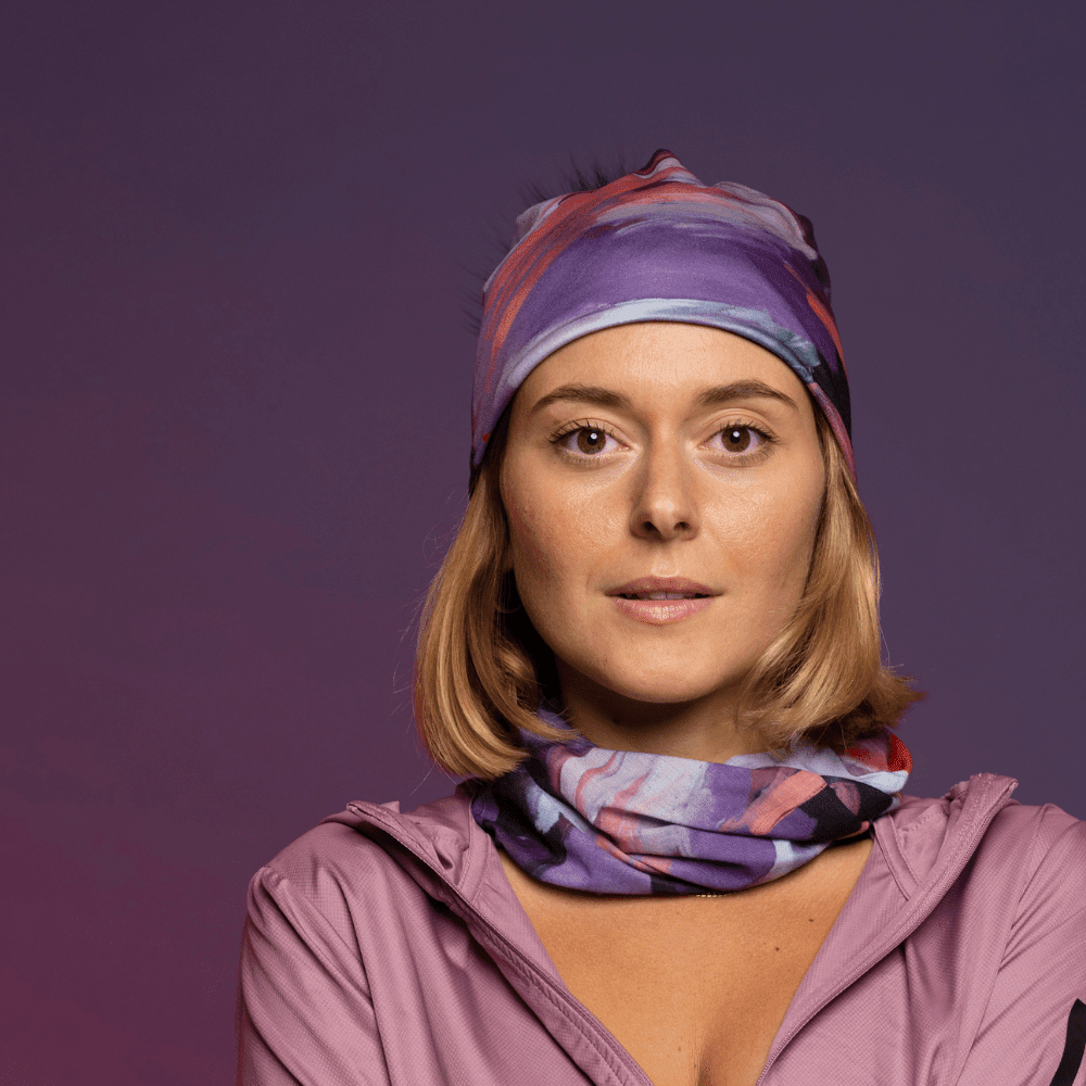 Woman wearing the Tulips Beanie and matching neck gaiter, styled with a pink hooded jacket.