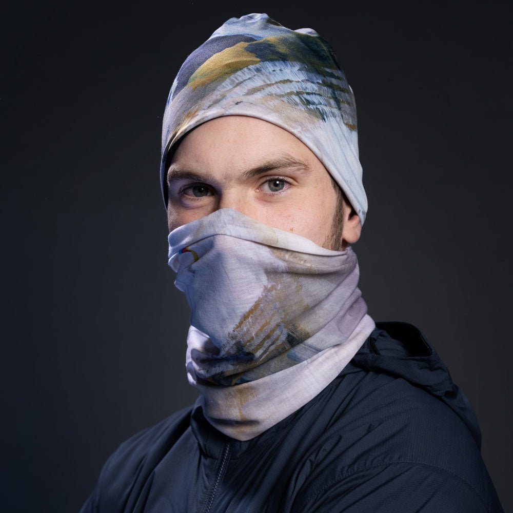 A man wearing the Unisex Sand Beanie and neck tube as a face covering.