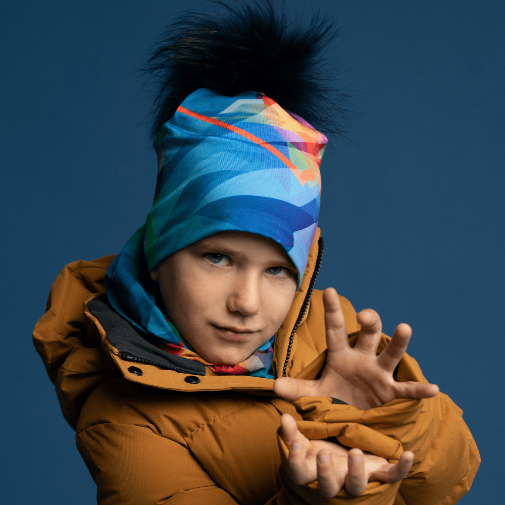 A young boy wearing the Unisexe Fast Triangles Beanie with a matching neck tube and mustard yellow winter jacket.