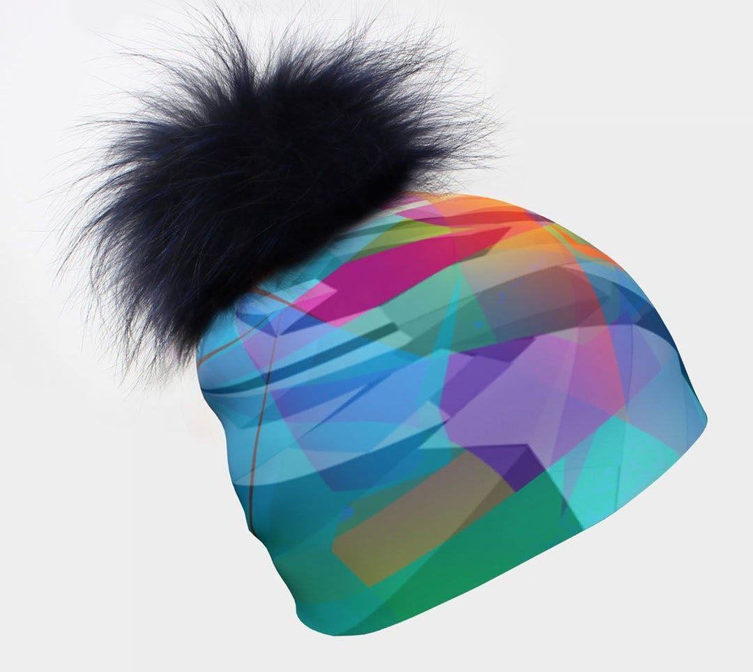 Close-up of a blue Unisexe Fast Triangles Beanie with a large, dark blue fluffy pompom against a white background.