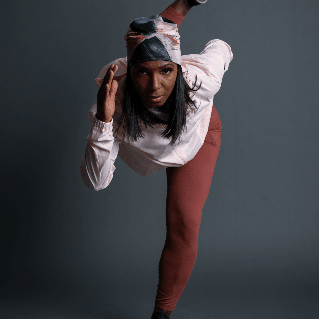 Woman in athletic wear wearing the Vie en Rose Beanie, striking a dynamic pose.