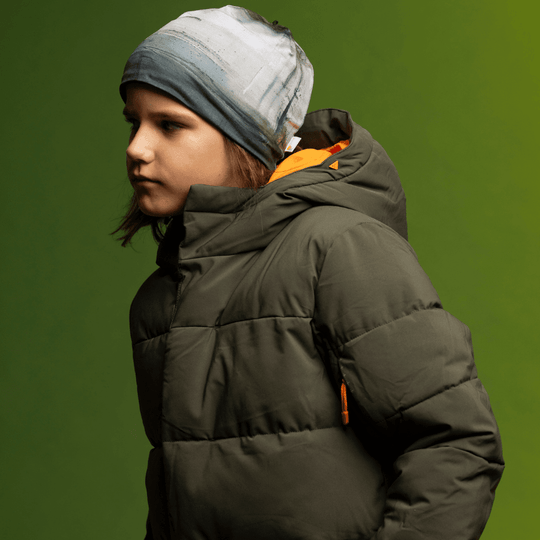 Child in a green winter jacket wearing the Wall Beanie, viewed from the side.
