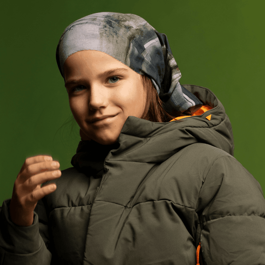 Young girl wearing the Wall Multifunctional Tube as a headband with a green puffer jacket.