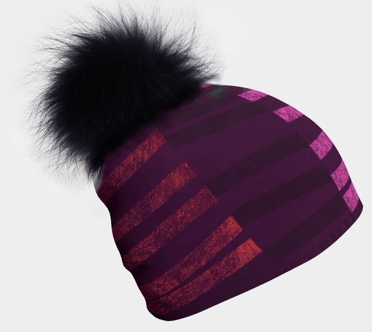Purple and pink striped beanie with a large black pom-pom.