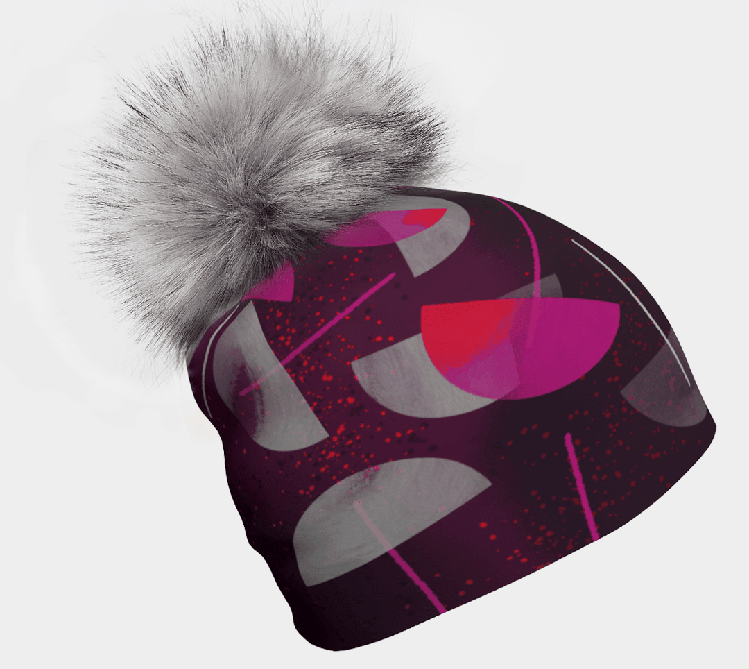 Women's beanie with magenta and gray abstract art pattern and a large gray pompom.