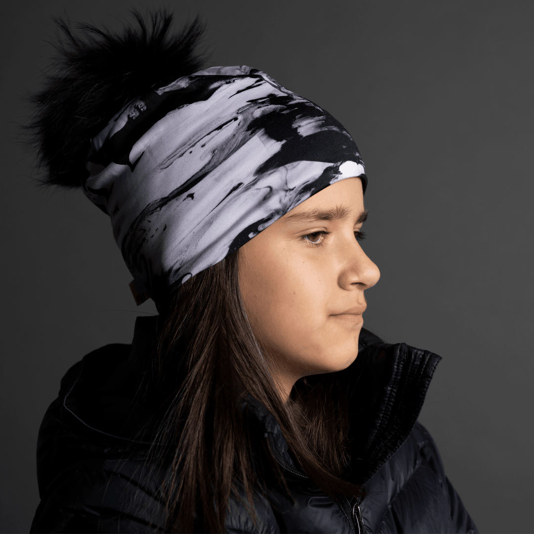 Side profile of a young girl wearing the black and white abstract pattern beanie.