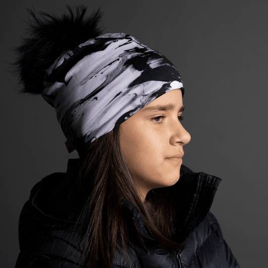 Side profile of a young girl wearing the black and white abstract pattern beanie.