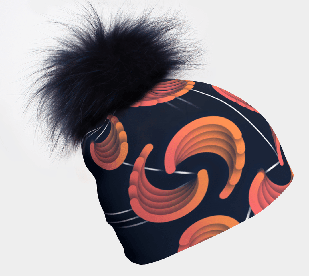 Women's beanie with navy pompom and abstract navy and orange pattern against a white background