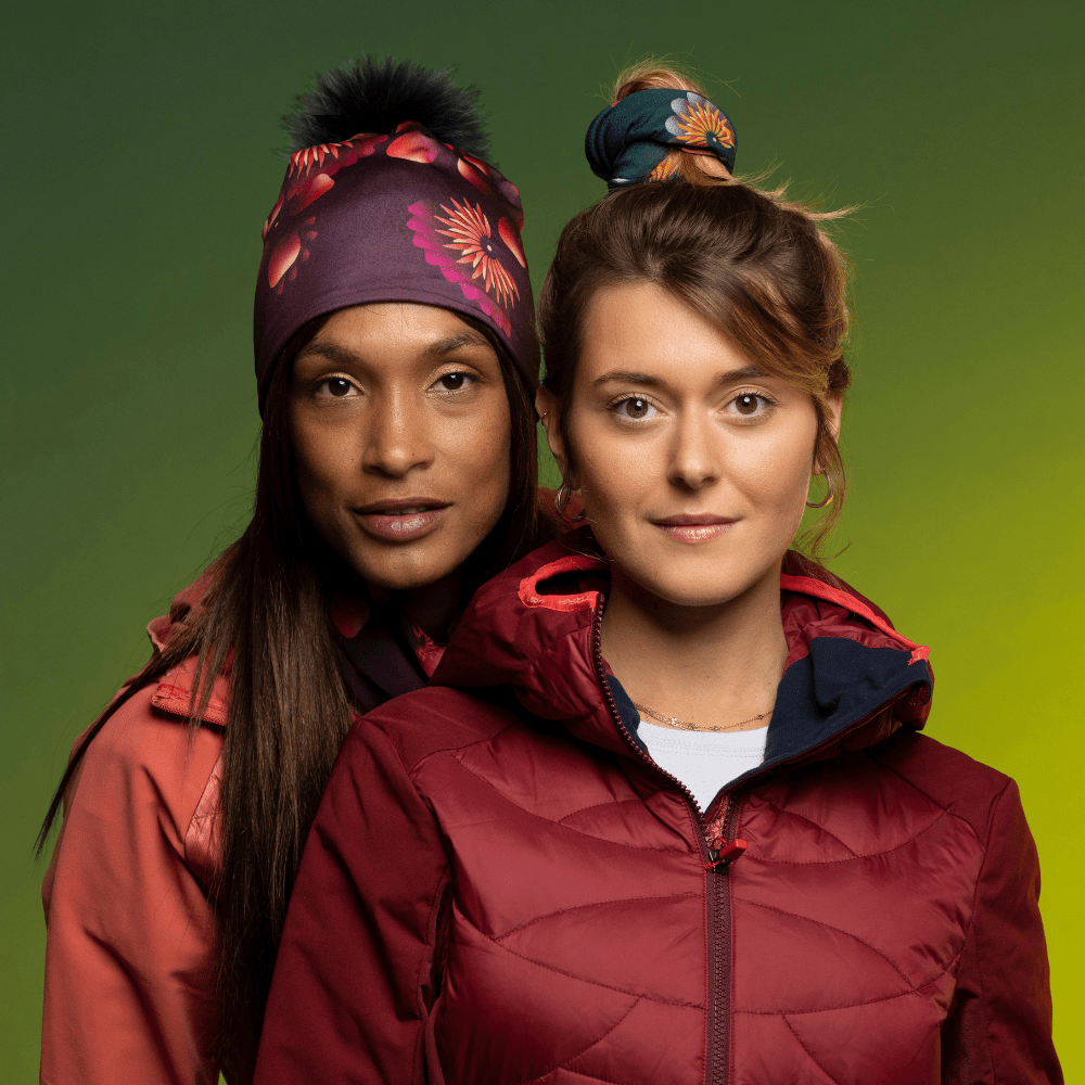 Woman wearing the Sunflower Read Beanie with Black Pompom from Zaire with the friend wearing the Sunflower Green Tube as hair Scrunchie. Lalita&